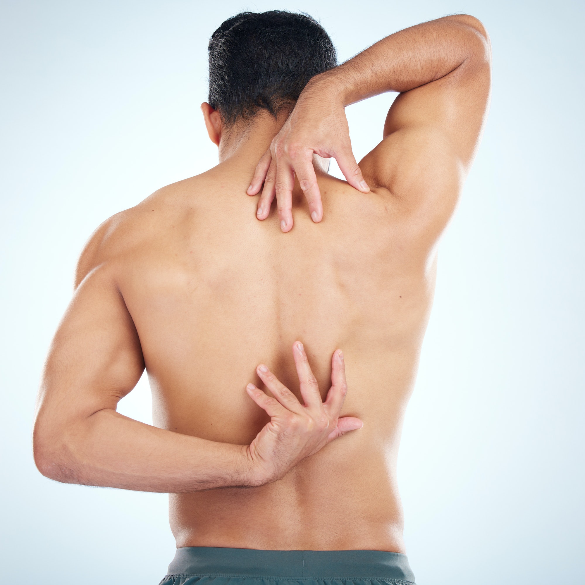Man, body or stretching back muscles on blue background in studio pain relief, healthcare wellness